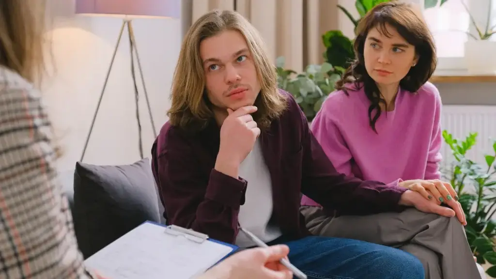 Two partners holding hands during a couples counseling session