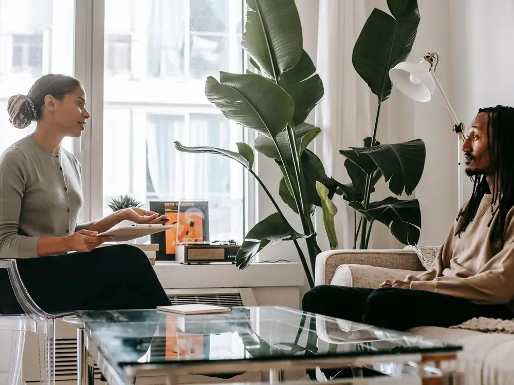 A therapist and client having a focused one-on-one counseling conversation in a bright office