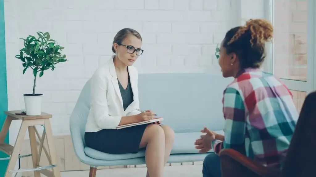 A therapist listening to a client during a private counseling session in a modern office